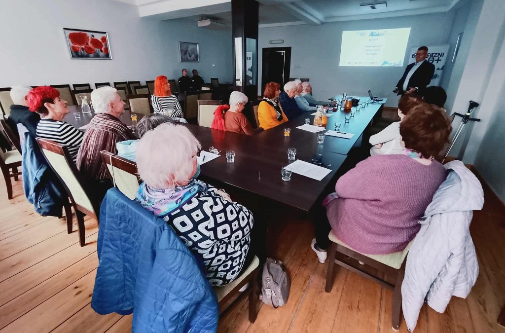 Seniorzy słuchający wykładu na temat bezpieczeństwa w ruchu drogowym.